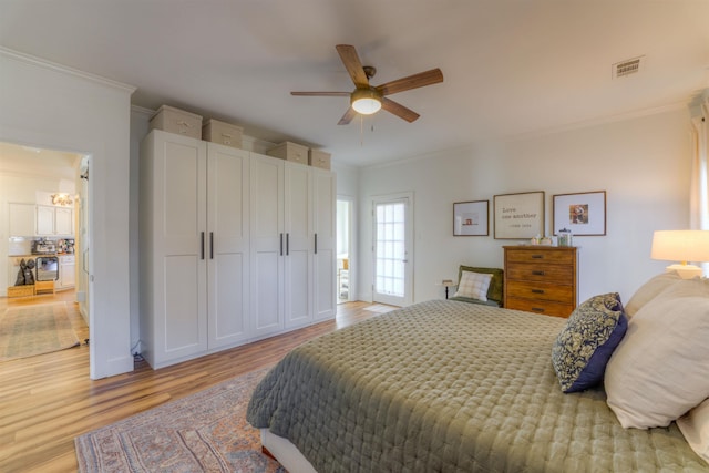 bedroom with a ceiling fan, light wood-style flooring, visible vents, and crown molding