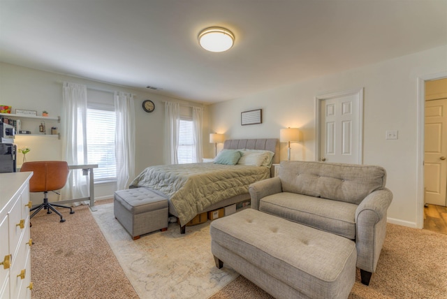 bedroom with light colored carpet, visible vents, and baseboards