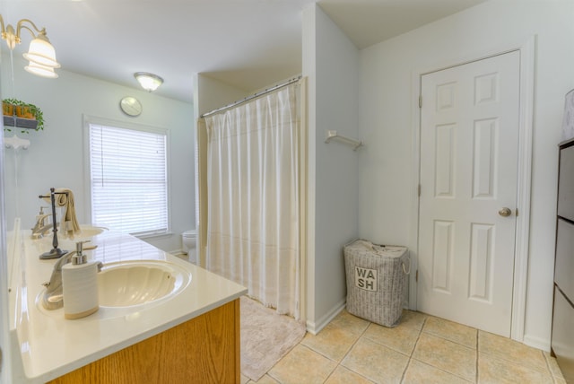 bathroom with toilet, curtained shower, tile patterned flooring, and vanity