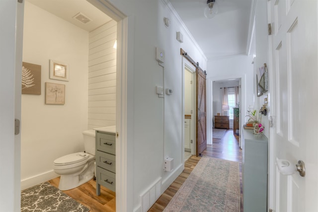 bathroom featuring toilet, baseboards, visible vents, and wood finished floors