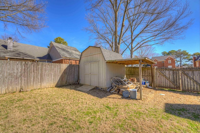 view of yard with an outbuilding, a gate, a fenced backyard, and a storage unit