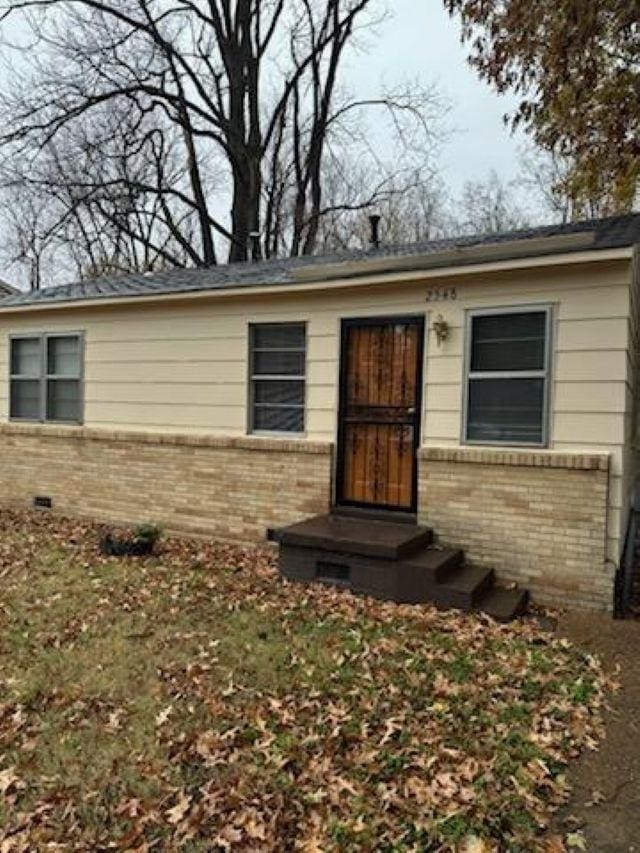 property entrance with brick siding and crawl space