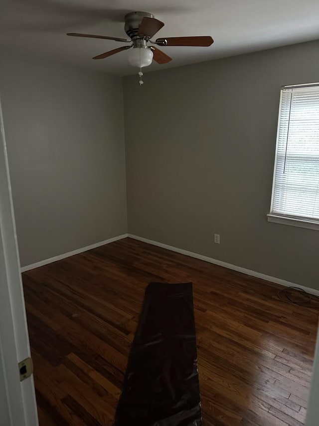 unfurnished room featuring ceiling fan, wood finished floors, and baseboards