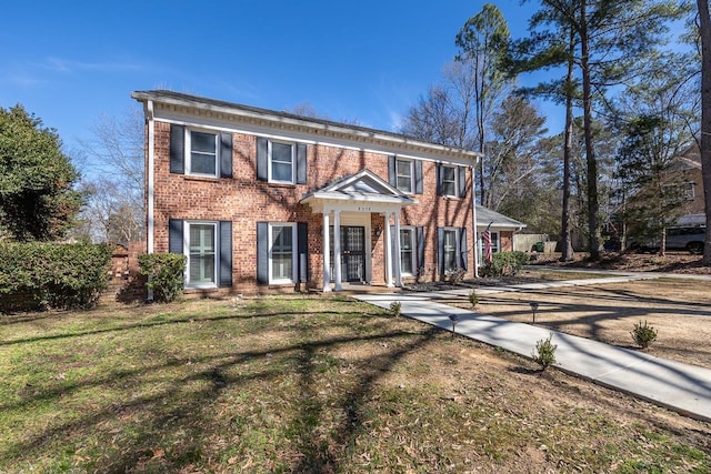 view of front of house featuring a front yard and brick siding