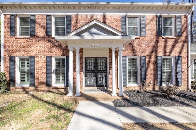 view of exterior entry featuring brick siding