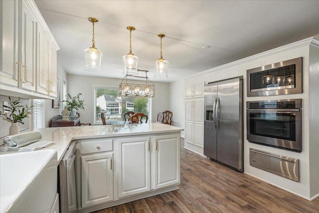 kitchen featuring a peninsula, white cabinetry, appliances with stainless steel finishes, and a warming drawer