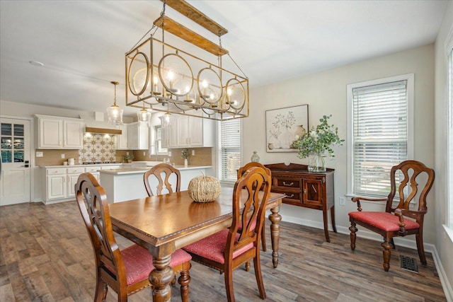 dining area featuring dark wood-type flooring, visible vents, and baseboards