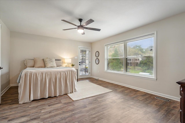 bedroom featuring access to exterior, visible vents, baseboards, and wood finished floors