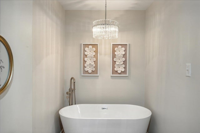 bathroom featuring a soaking tub and an inviting chandelier