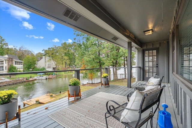 deck featuring a water view and visible vents