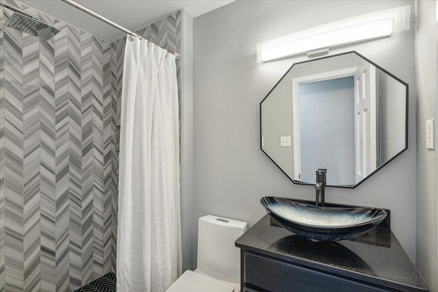 bathroom featuring toilet, a shower with shower curtain, and vanity