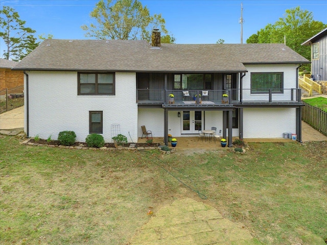 back of house featuring a lawn, a patio, a balcony, a chimney, and french doors