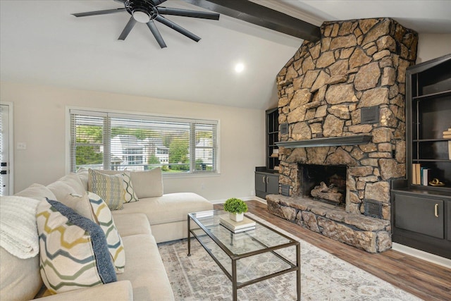 living room with lofted ceiling with beams, a fireplace, wood finished floors, a ceiling fan, and baseboards