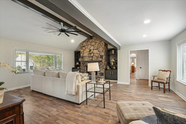 living area with vaulted ceiling with beams, wood finished floors, and baseboards