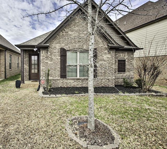 view of front of home featuring a front yard and brick siding