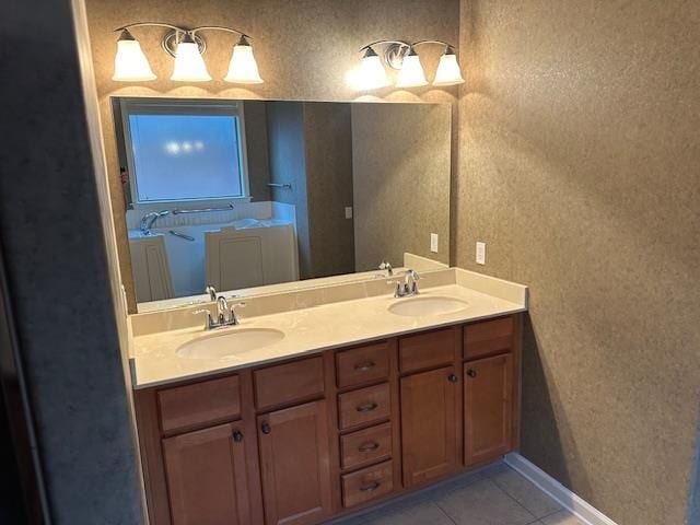 bathroom featuring tile patterned flooring, a sink, baseboards, and double vanity