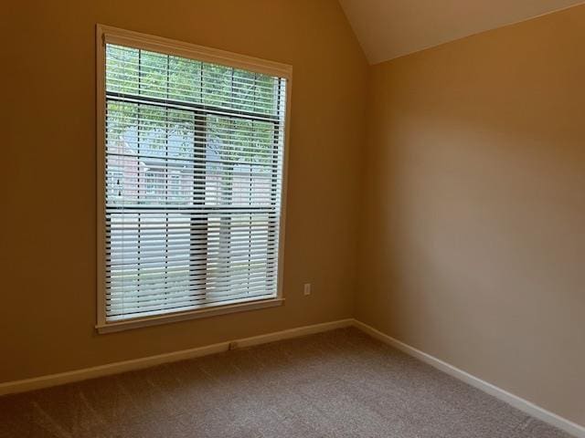 unfurnished room featuring vaulted ceiling, carpet, and baseboards