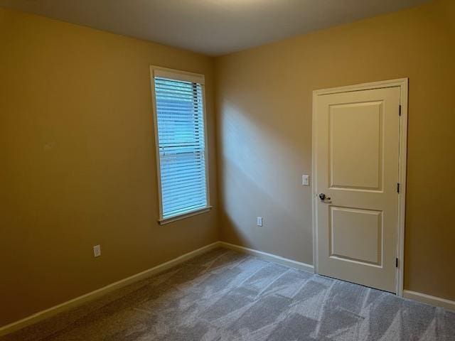 carpeted spare room with baseboards