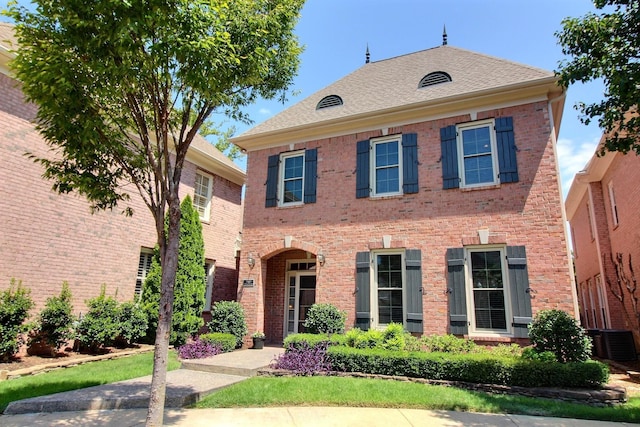 view of front of home featuring a shingled roof and brick siding