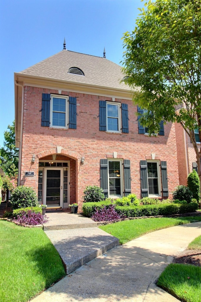 view of front of home featuring brick siding and a front lawn