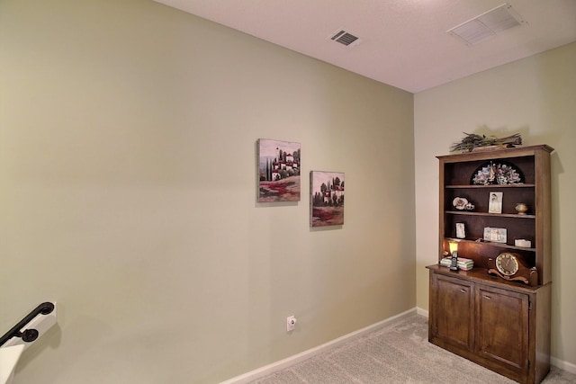 office space with light colored carpet, visible vents, and baseboards