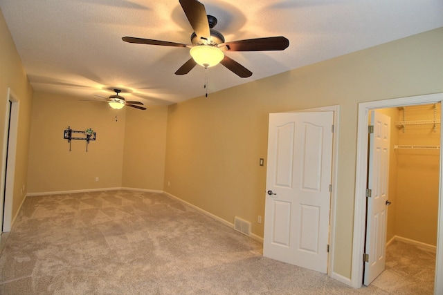 spare room with light colored carpet, visible vents, baseboards, and a textured ceiling