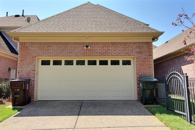 garage with fence and concrete driveway