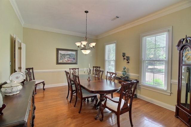 dining area featuring a chandelier, a healthy amount of sunlight, visible vents, and light wood-style floors