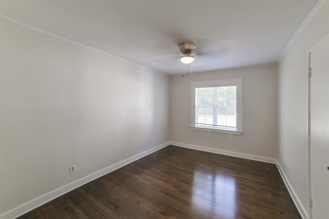 spare room featuring crown molding, ceiling fan, dark wood-style flooring, and baseboards