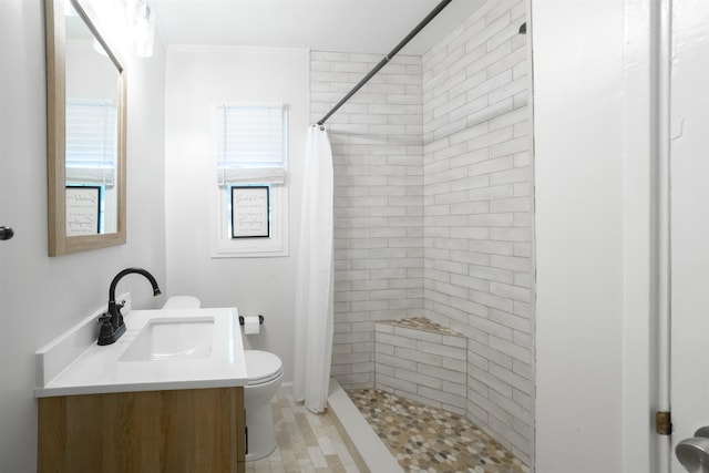 full bath featuring ornamental molding, tiled shower, vanity, and toilet