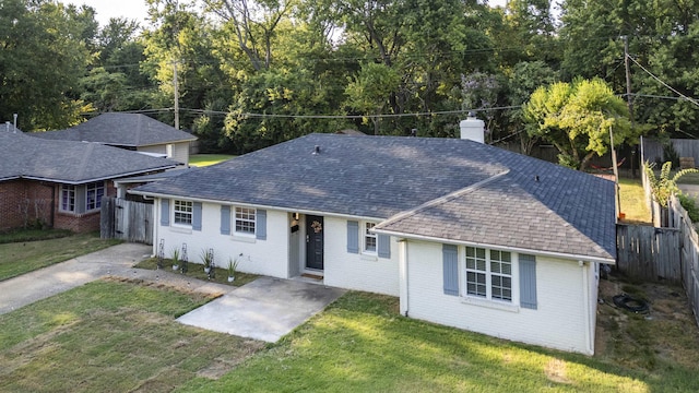 single story home featuring brick siding, a chimney, a front yard, and fence