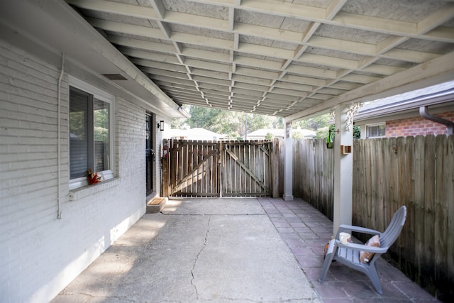 view of patio with a gate, fence, and an attached carport