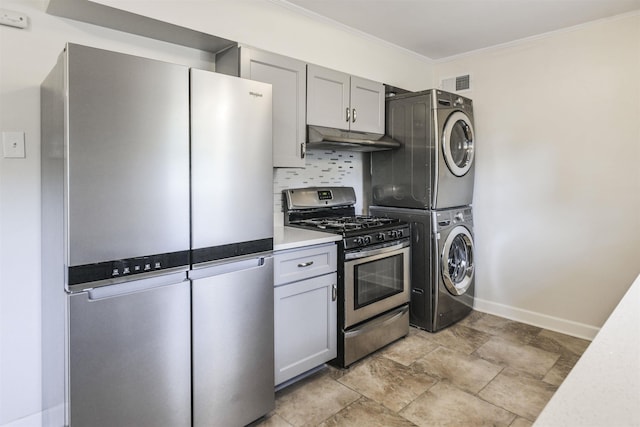 kitchen with stainless steel appliances, gray cabinets, under cabinet range hood, and stacked washer / drying machine