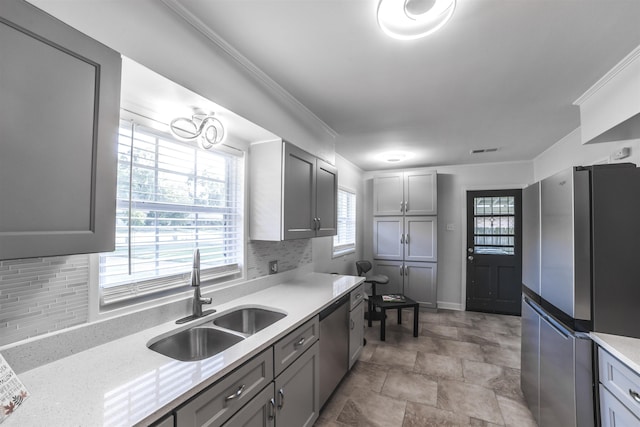 kitchen featuring stainless steel appliances, a sink, visible vents, light countertops, and crown molding