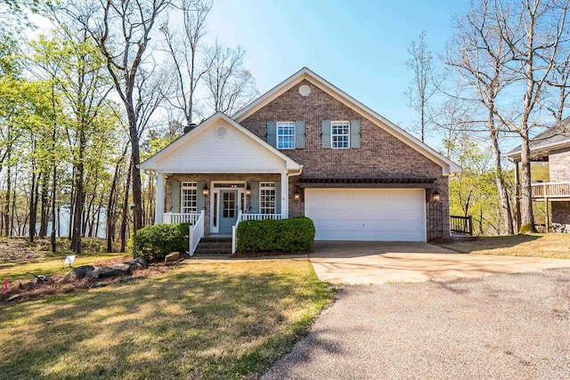 view of front facade with a front yard, a porch, concrete driveway, and brick siding