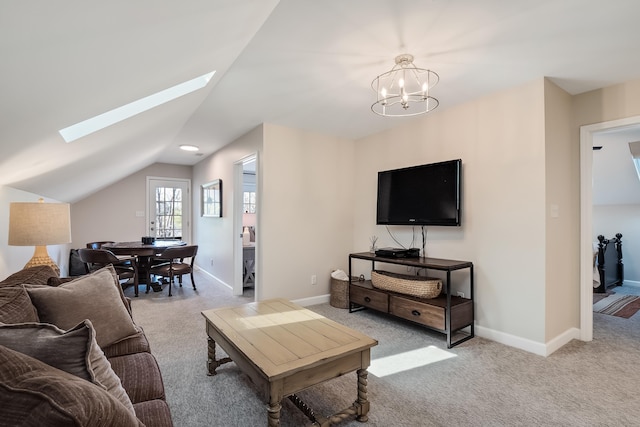 carpeted living area with vaulted ceiling with skylight, baseboards, and an inviting chandelier