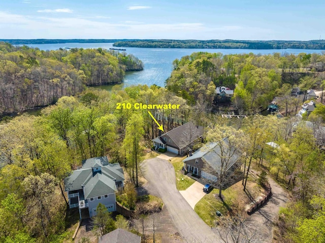 birds eye view of property featuring a water view and a wooded view