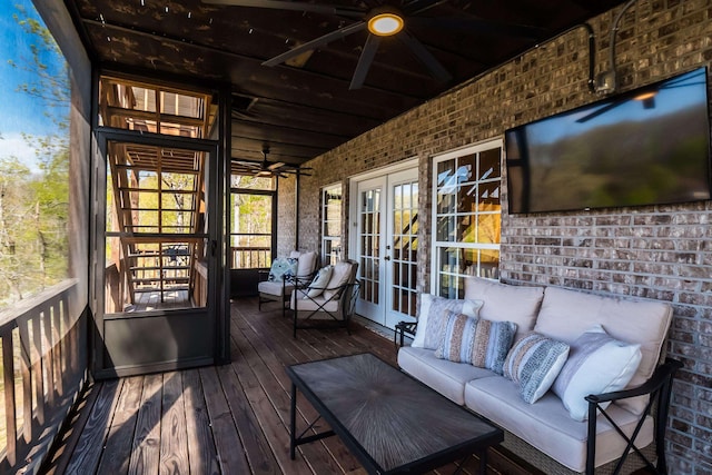 wooden deck featuring outdoor lounge area, a ceiling fan, and french doors