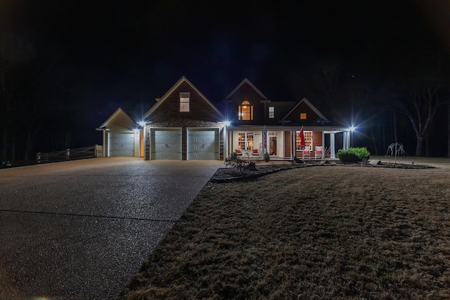 traditional-style house with driveway, an attached garage, and a lawn