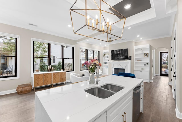 kitchen with open floor plan, wood finished floors, arched walkways, and dishwasher