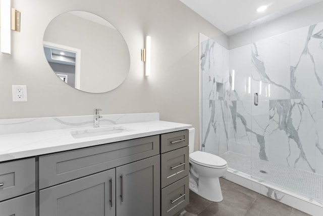 bathroom featuring vanity, a marble finish shower, and toilet