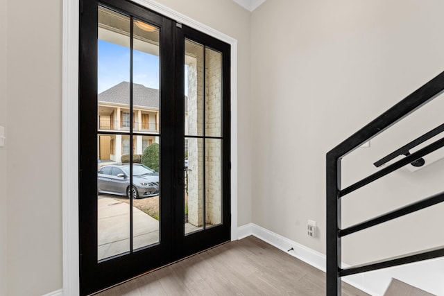 foyer entrance featuring french doors, wood finished floors, and baseboards