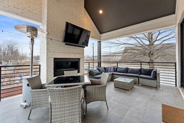 view of patio / terrace featuring a balcony and an outdoor living space with a fireplace