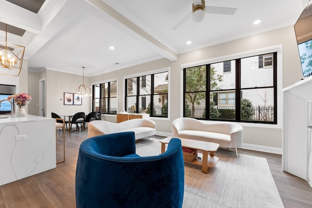 living area with recessed lighting, ornamental molding, wood finished floors, beamed ceiling, and baseboards