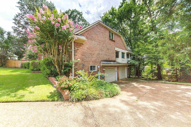 view of home's exterior with a garage, brick siding, a yard, and driveway