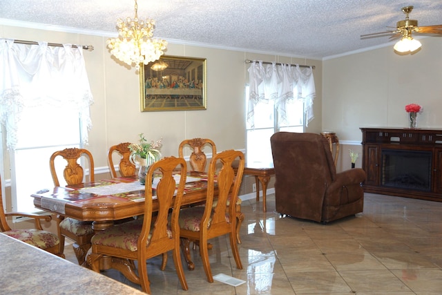 dining room with a textured ceiling, a fireplace, crown molding, and ceiling fan with notable chandelier