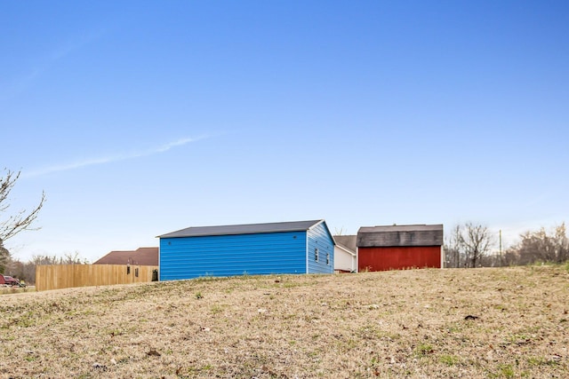 view of yard with fence and an outbuilding