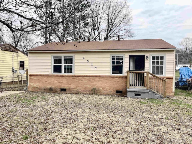 view of front of house with crawl space, brick siding, and fence