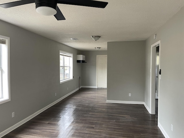 unfurnished room with dark wood-style floors, visible vents, baseboards, and ceiling fan