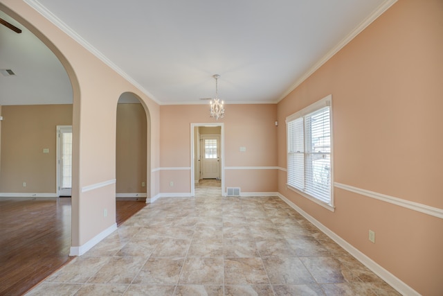 empty room with arched walkways, crown molding, visible vents, an inviting chandelier, and baseboards